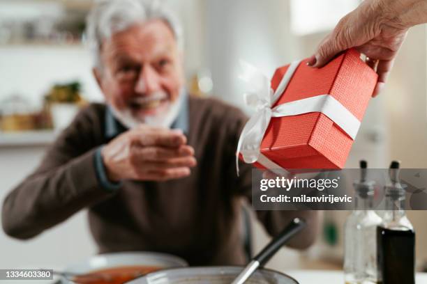 portrait of senior man with gift. - fathers day lunch stock pictures, royalty-free photos & images