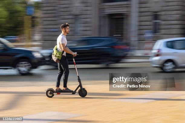 joven estudiante evitando el tráfico con scooter eléctrico - scooter city fotografías e imágenes de stock