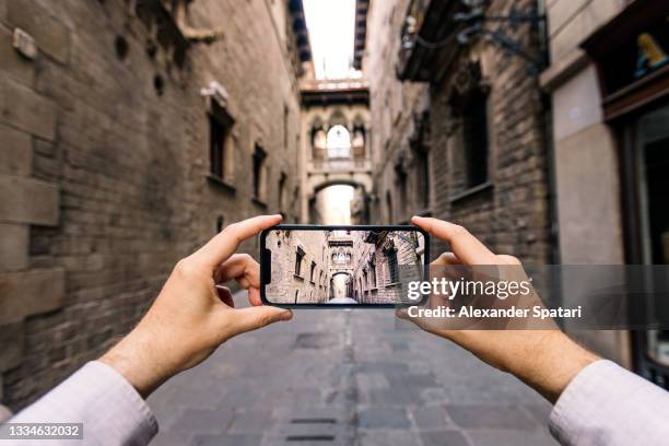 tourist photographing street in barcelona using smart phone, personal perspective pov - augmented reality phone stock pictures, royalty-free photos & images