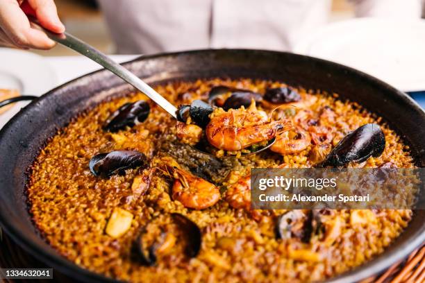 man eating paella with seafood at the restaurant - paella stockfoto's en -beelden