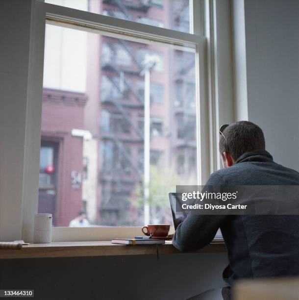 Man sitting in coffee shop window