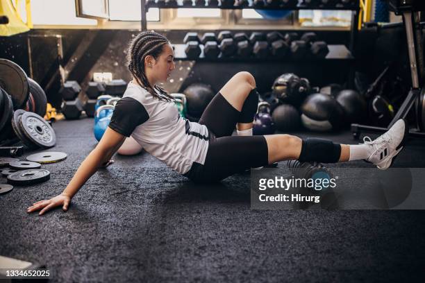 young woman massaging calf in gym - calf human leg stock pictures, royalty-free photos & images