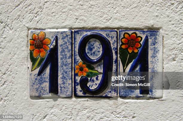 number 191 street address in tiled numbers inset into a stucco wall painted white - house number stock pictures, royalty-free photos & images