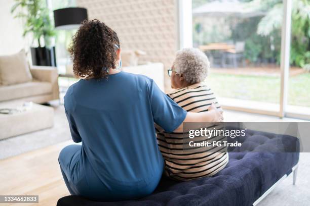 home caregiver talking to and consoling senior patient at home - 老人痴呆症 個照片及圖片檔