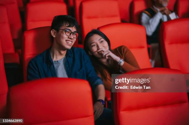 asian chinese young couple enjoy watching movie show in cinema bonding time - asian watching movie stock pictures, royalty-free photos & images