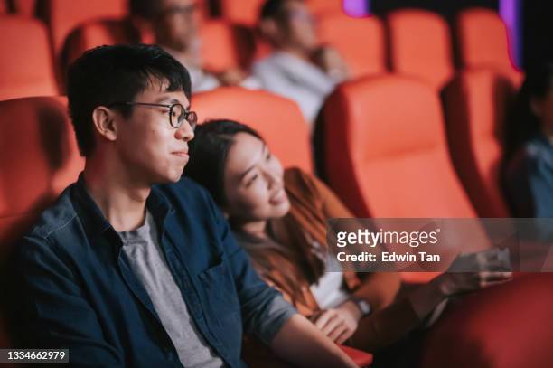 asian chinese young couple enjoy watching movie show in cinema bonding time - film festival stock pictures, royalty-free photos & images