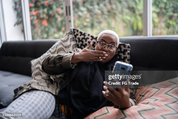 woman blowing a kiss during video call at home - blowing a kiss stockfoto's en -beelden