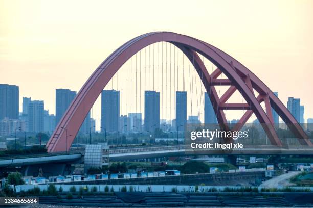 looking at an arch bridge on the qiantang river in hangzhou, china from a high-rise building - kettingbrug hangbrug stockfoto's en -beelden