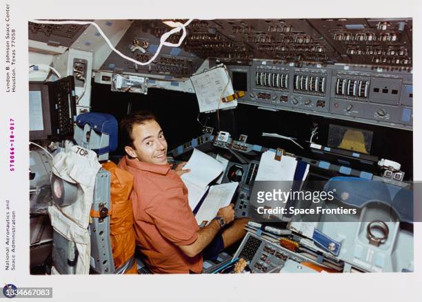 Jean-Francois Clervoy, mission specialist, representing the European Space Agency , looks over a checklist at the commander's station on the Space...