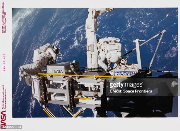 Astronauts Kathryn C Thornton and Thomas D Akers seen on the STS-49 mission's fourth period of extravehicular activity as they work with components...