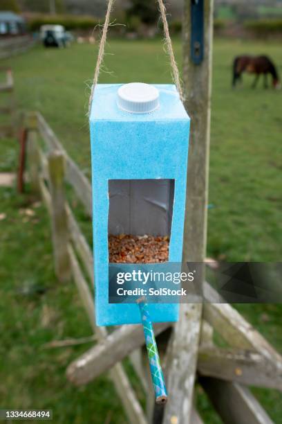 milchkarton recycelt als vogelfutter - vogelfutterspender stock-fotos und bilder