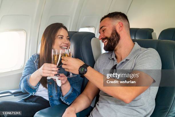 pareja joven volando y brindando. - first class fotografías e imágenes de stock