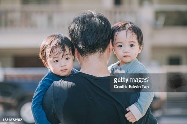 rear view asian chinese father carrying his twin baby boys walking back home in the morning from public park - asian twins stock pictures, royalty-free photos & images