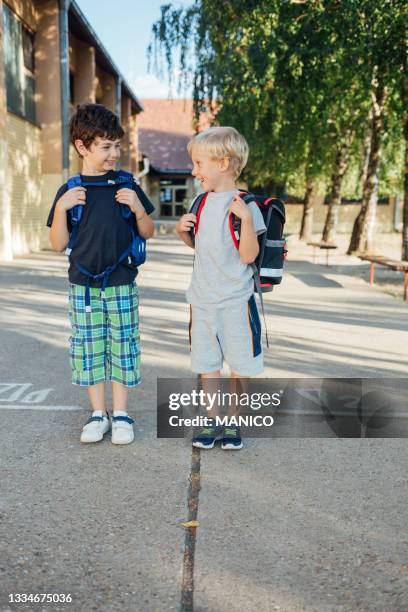 deux garçons heureux qui quittent l’école - enfant cartable photos et images de collection