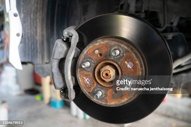 disc brake of the vehicle for repair, in process of new tire replacement. car brake repairing in garage.close up. - car brakes fotografías e imágenes de stock