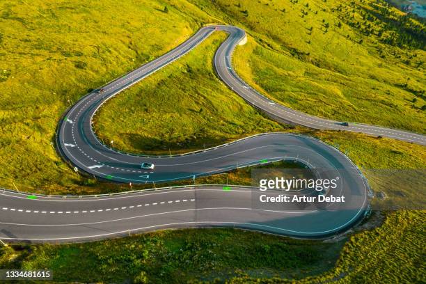 drone view of curvy mountain road in the pyrenees with beautiful light. - andorra stock pictures, royalty-free photos & images