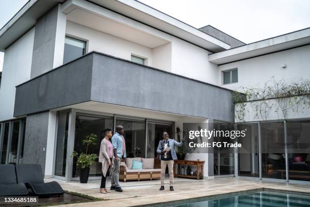 agent immobilier montrant une nouvelle maison aux clients - real people lifestyle photos et images de collection