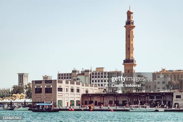 dubai creek with old neighborhood buildings and minaret - dubai deira stock pictures, royalty-free photos & images