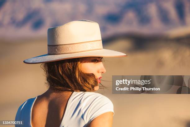 close up of beautiful woman wearing hat in desert dunes - beautiful woman nature stock pictures, royalty-free photos & images