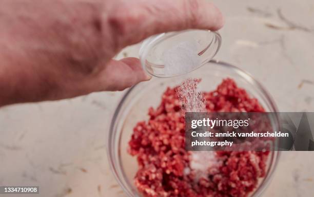 salt in hamburger preparation - adicionar sal imagens e fotografias de stock