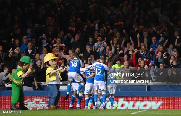 Siriki Dembele of Peterborough United celebrates with team mates, mascots and fans after scoring his team's second goal during the Sky Bet...