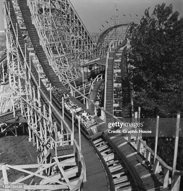 Amusement park visitors riding an unspecified rollercoaster at the Palisades Amusement Park in Bergen County, New Jersey, circa 1950.