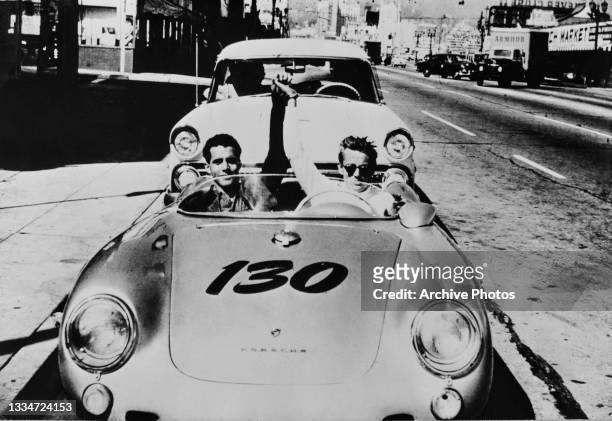 German mechanic Rolf Wutherich and American actor James Dean who sits at the wheel, their hands joined and raised triumphantly, in Dean's Porsche 550...