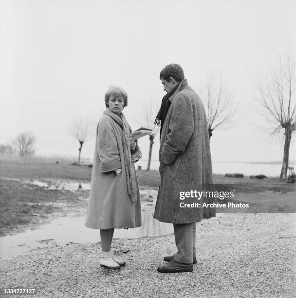 French actress and singer Jeanne Moreau and French actor Jean-Paul Belmondo on the set of 'Moderato cantabile' , location unspecified, 1960. The...