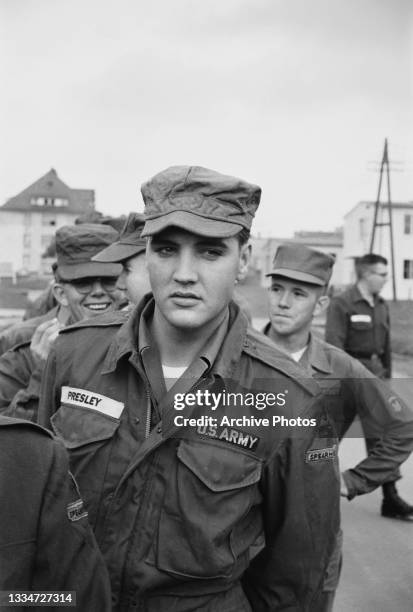 American singer and actor Elvis Presley dressed in military fatigues along with unspecified military personnel, stationed with the 3rd Armored...