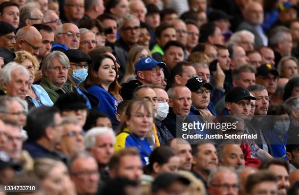 Fans wearing a PPE mask sit amongst the crowd during the Sky Bet League One match between AFC Wimbledon and Gillingham at Plough Lane on August 17,...
