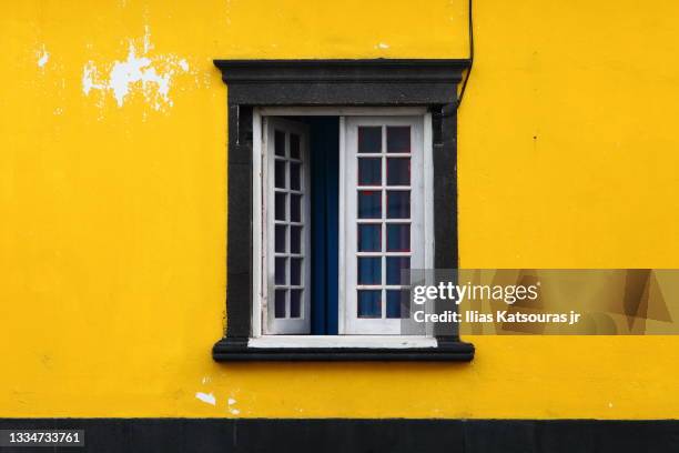 open casement window on yellow wall - jr wall stock pictures, royalty-free photos & images