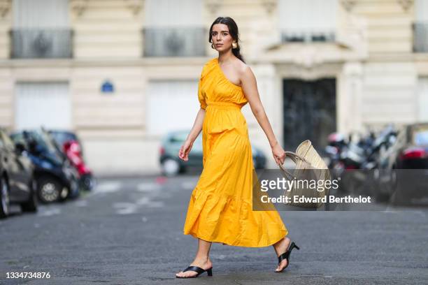 Ketevan Giorgadze @katie.one wears a one shoulder cut out maxi dress in orange from Mango, oversized golden hoop earrings from Zara, flip flop heeled...