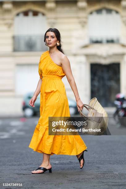 Ketevan Giorgadze @katie.one wears a one shoulder cut out maxi dress in orange from Mango, oversized golden hoop earrings from Zara, flip flop heeled...