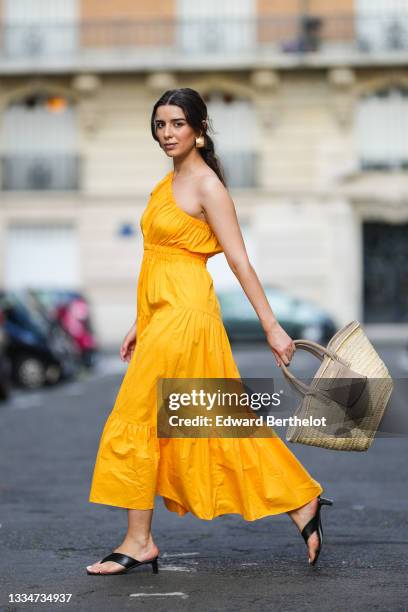 Ketevan Giorgadze @katie.one wears a one shoulder cut out maxi dress in orange from Mango, oversized golden hoop earrings from Zara, flip flop heeled...