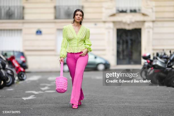 Ketevan Giorgadze @katie.one wears neon pink high-waisted wide leg denim jeans from Zara, a neon green ruffle embroidered low-neck v-neck blouse with...