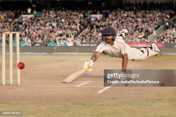 batsman diving while taking a run during a match - crease cricket field stockfoto's en -beelden