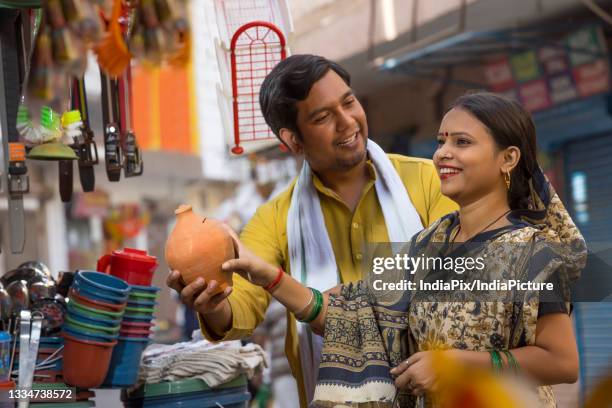 a rural husband happily looking at wife while holding piggy bank - gullak bildbanksfoton och bilder