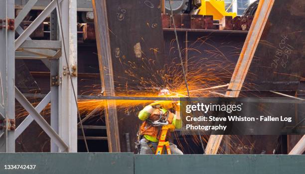 sparks fly around a construction worker working on a major building site in new york city - sparks fly stock pictures, royalty-free photos & images