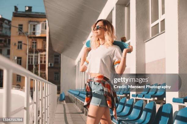 beautiful woman hipster enjoying summer while holding a skateboard - denim shorts stock pictures, royalty-free photos & images