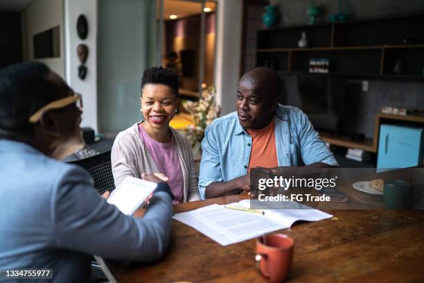 couple shaking hand with real estate agent setting a deal - financial planning stock pictures, royalty-free photos & images