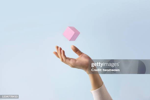 hand catching a cube in mid air still life. - catch stockfoto's en -beelden