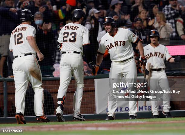 San Francisco Giants' Kris Bryant and Alex Dickerson are congratulated by Darin Ruf after Bryant hit a two-run home run off New York Mets relief...
