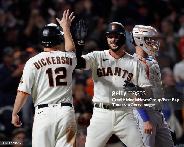 San Francisco Giants' Kris Bryant is congratulated by Alex Dickerson after hitting a two-run home run off New York Mets relief pitcher Miguel Castro...