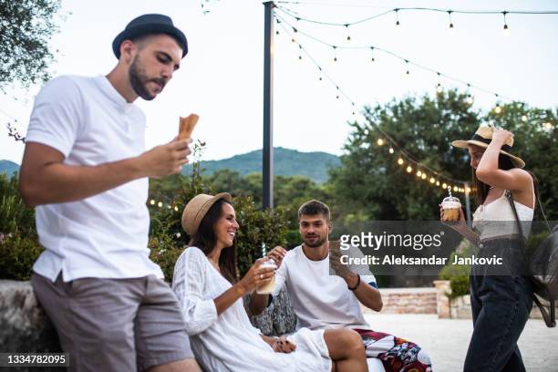 junge erwachsene freunde, die im sommer in einem park abhängen - ice cream cup stock-fotos und bilder