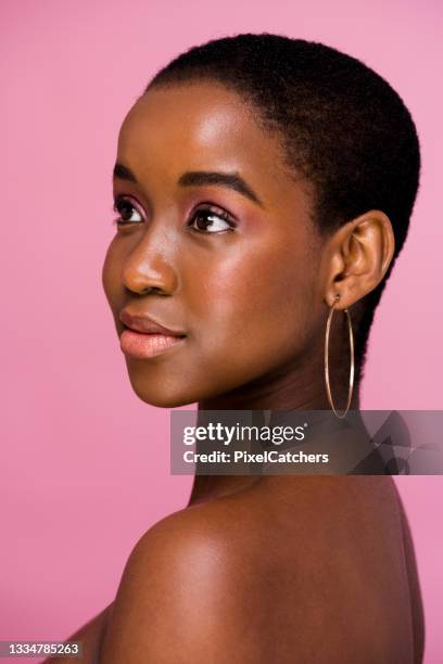 schönes junges afrikanisches model posiert für schulterporträt mit rosa hintergrund - blusher stock-fotos und bilder