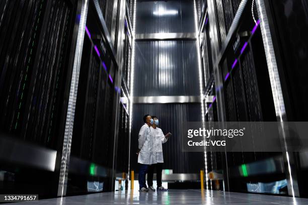 Staff members inspect the phase-change immersion high-performance computing system at Hefei Advanced Computing Center, a major scientific and...