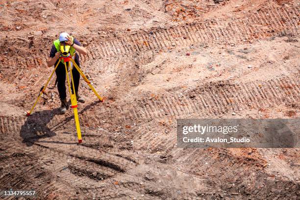 surveyor working at new construction site - theodolite stock pictures, royalty-free photos & images
