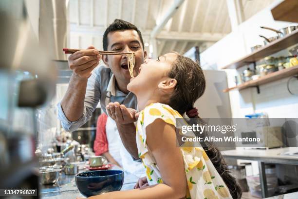 father and daughter having fun - asian cooking stock-fotos und bilder