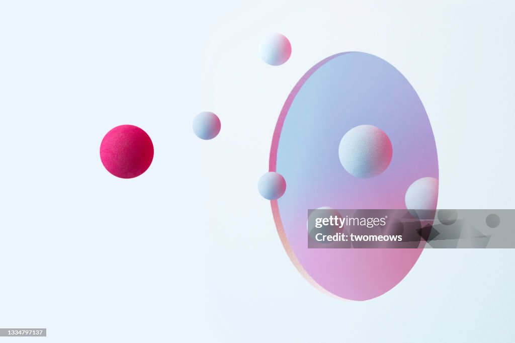 Abstract spheres flowing through a circle shaped opening.