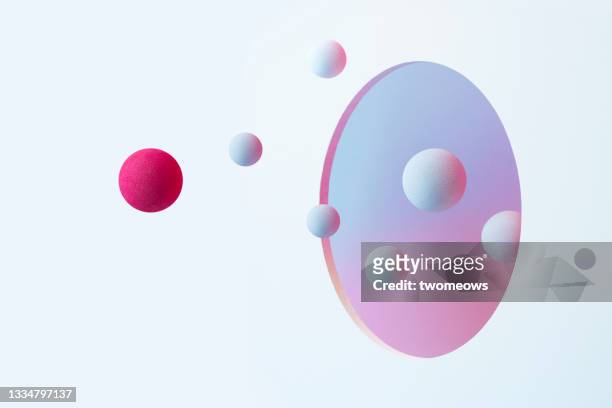 abstract spheres flowing through a circle shaped opening. - sphere stock pictures, royalty-free photos & images